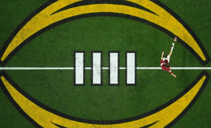 A player warms up on the College Football Playoff logo